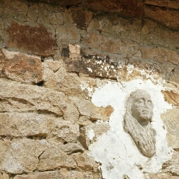 Le Faouët. - Saint-Fiacre : maison, en face de la chapelle, visage sculpté au mur.